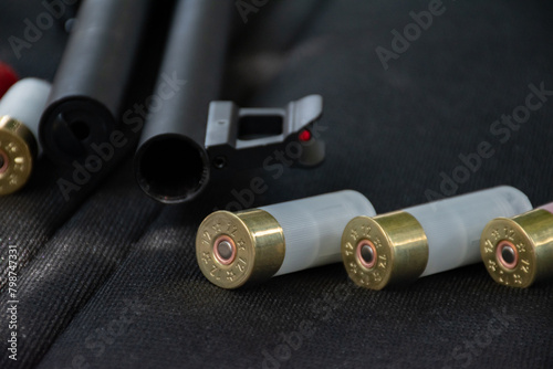 Shotgun, shotgun cartridges on a black leather background, soft and selective focus