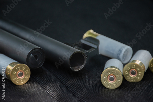 Shotgun, shotgun cartridges on a black leather background, soft and selective focus photo