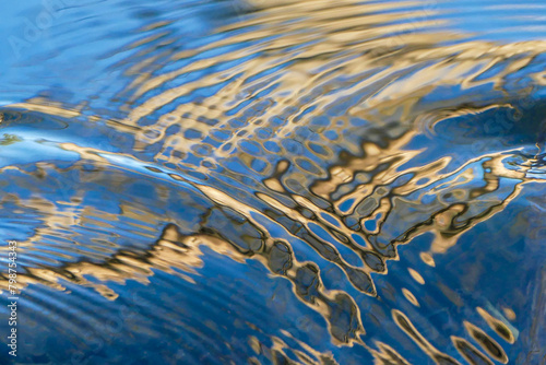 Blaue und goldene Spiegelung auf einer Wasseroberfläche
