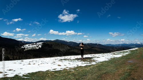 A woman does yoga and meditates high in the snowy mountains on a sunny day. The concept of yoga and meditation. Concern for mental health