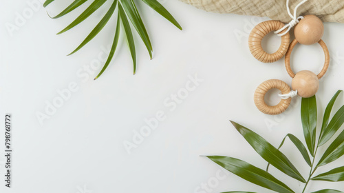 Minimalistic composition of green palm leaves, beige fabric and wooden teether on a white background. Copy of space. photo