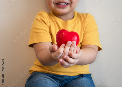 red heart in hand fat kid put yellow tight shirt, health care, organ donation, family life insurance, world heart day,brain stroke.