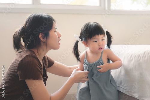 Asian mother disciplining her child, Asian girl kid being defiant with mom, Terrible two concept. photo