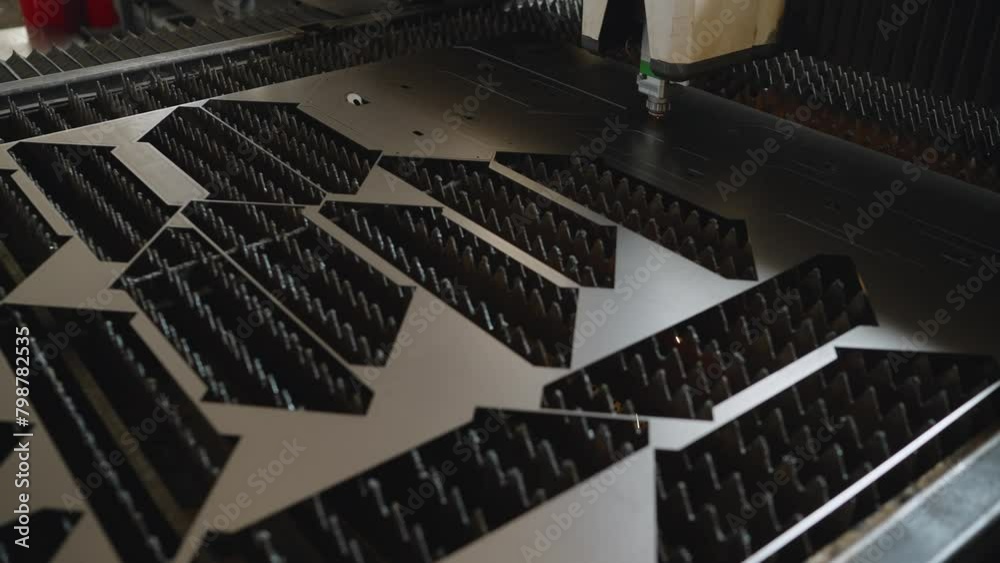 The machine cuts metal, close-up. A laser cutting machine cuts a metal plate. High-tech sheet metal production process using a laser cutting machine. The machine cuts metal, close-up. A laser cutting machine cuts a metal plate. High-tech sheet metal production process using a laser cutting machine.