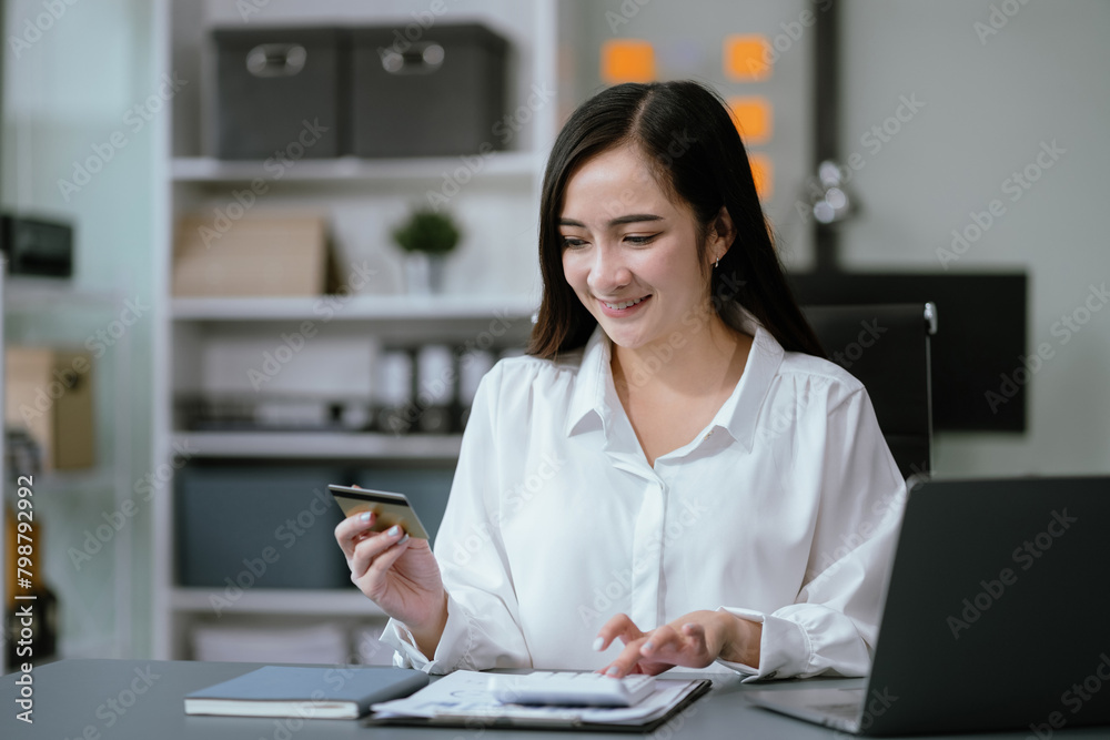 Women using calculator with credit cards, conduct financial transactions via laptop and data documents, put on the desk in the morning. Women using calculator with credit cards, conduct financial transactions via laptop and data documents, put on the desk in the morning.