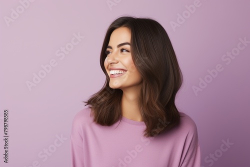 Portrait of happy smiling young woman looking up, over violet background