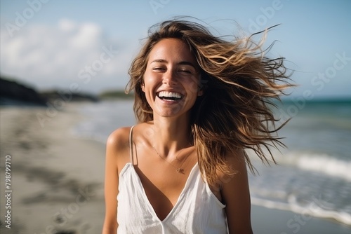 Portrait of a happy young woman with her hair blowing in the wind