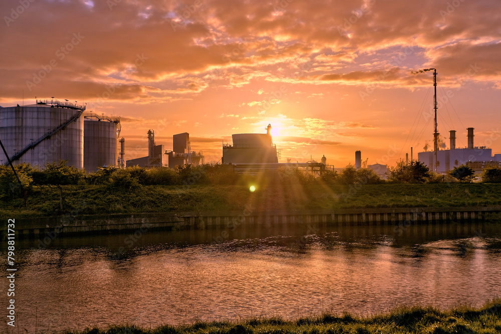 Naklejka premium HDR Oil refinery, cooling towers, with smoke, the sun setting.