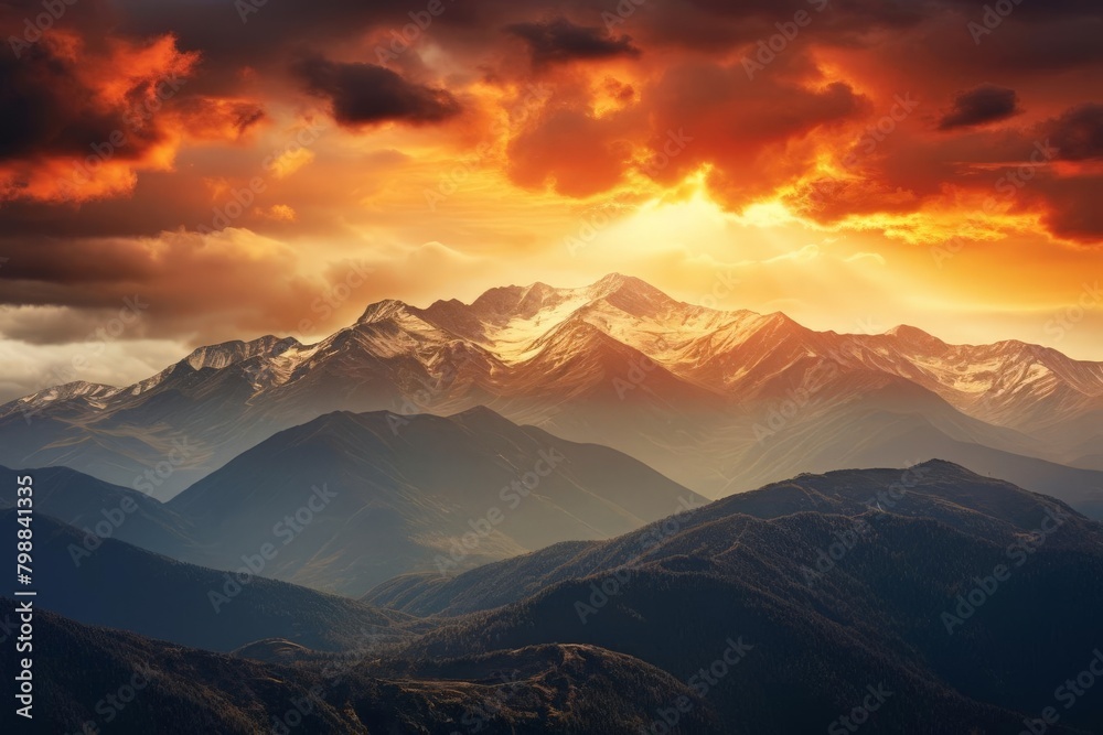 A beautiful landscape of snow-capped mountains at sunset with vibrant red and orange clouds.