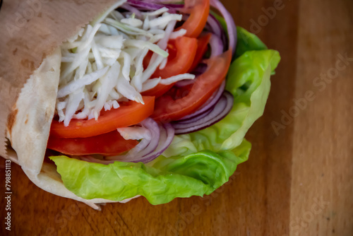 A delightful vegetarian healthy sandwich bursting with flavors. Crisp green salad leaves, juicy tomatoes, savory white cheese, and zesty onions, all nestled between slices of fresh bread