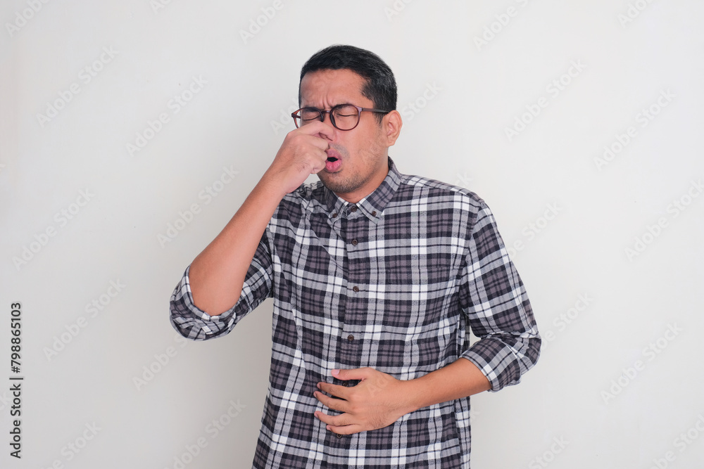 A man close his nose showing nauseous