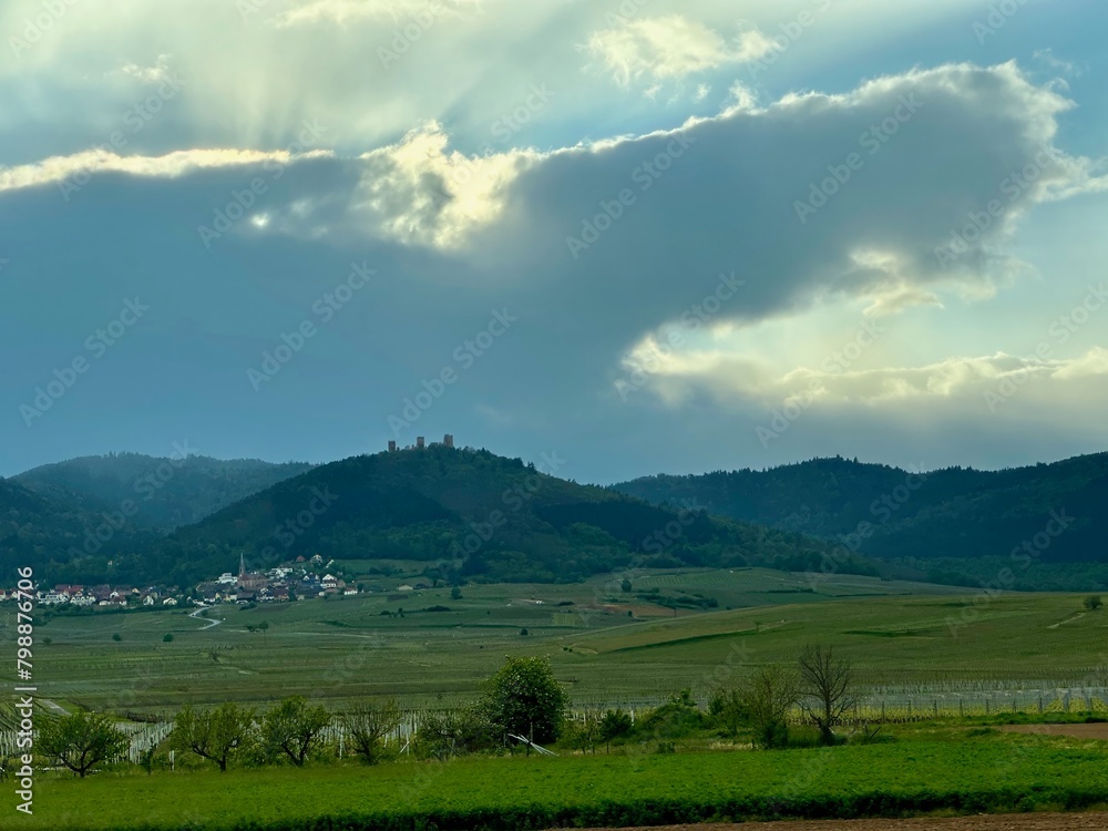 Majestic Sunbeams Over Eguisheim: The Three Castles Amidst Verdant Alsace Vineyards in Spring