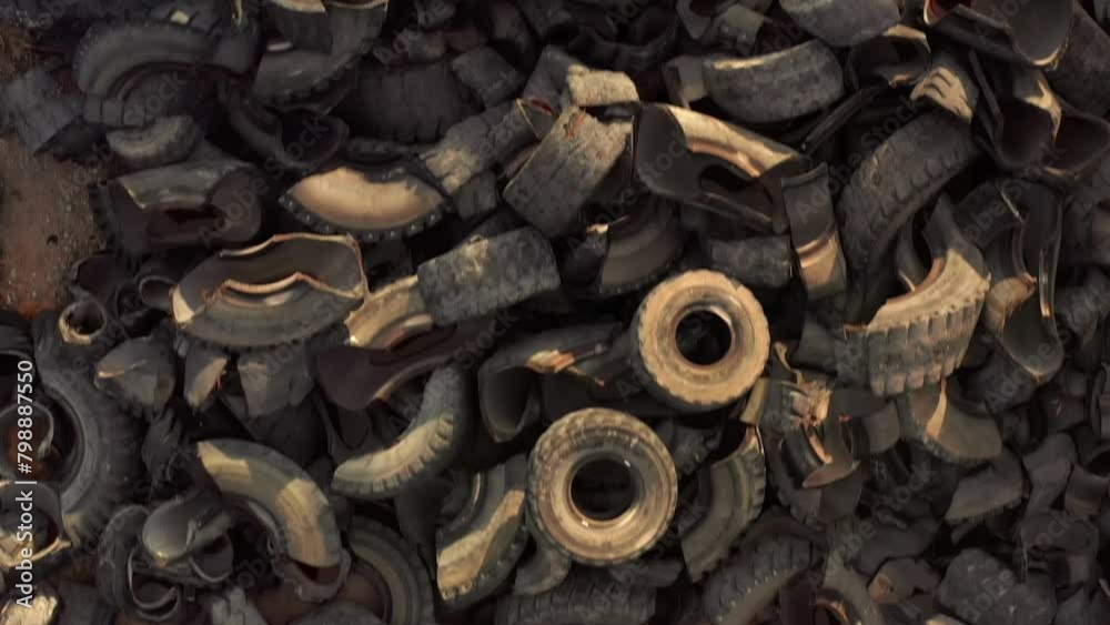 A lot of wheel tires dumped in landfill, aerial view. Old tires being. Industrial factory for processing of waste tires. A lot of wheel tires dumped in landfill, aerial view. Old tires being. Industrial factory for processing of waste tires.