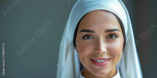 A catholic nun woman dressed as a Catholic nun smiles at the camera, against a white background photo