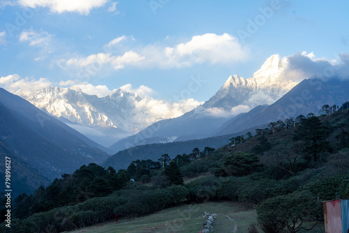Darkened fields and mountain peaks still shining with sunlight © sayrhkdsu