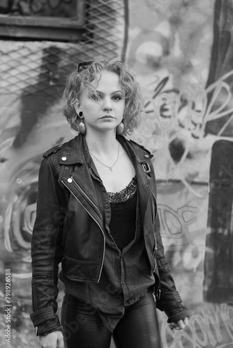 Beautiful cool caucasian white young woman posing. Finnish model with black leather jacket, sunglasses in a black and white street photography.