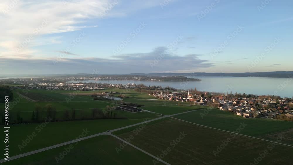 Stunning drone shot of Lake Constance in Switzerland, border with Germany. Drone flies over green area on one side of Lake Constance. 
