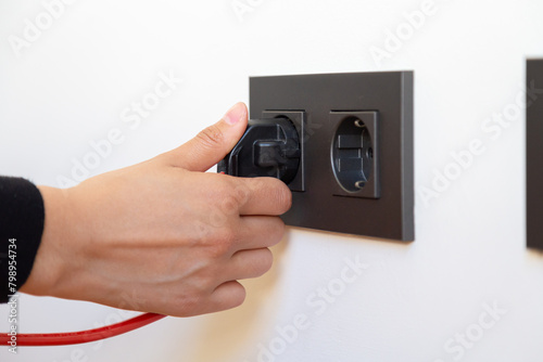 Woman's hand plugging in electrical appliance