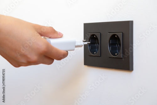 Woman's hand plugging in electrical appliance