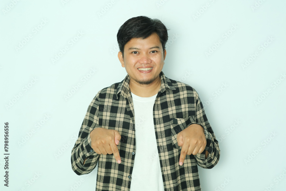 Young Asian man smiling happy while pointing down Young Asian man smiling happy while pointing down