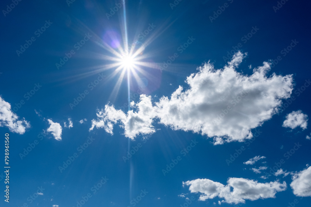 blue sky with clouds and sun beams