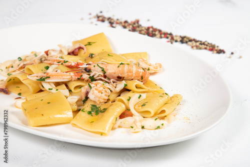 Paccheri allo scoglio is a italian food dish with pasta, seafood, shellfish and cherry tomatoes. photo