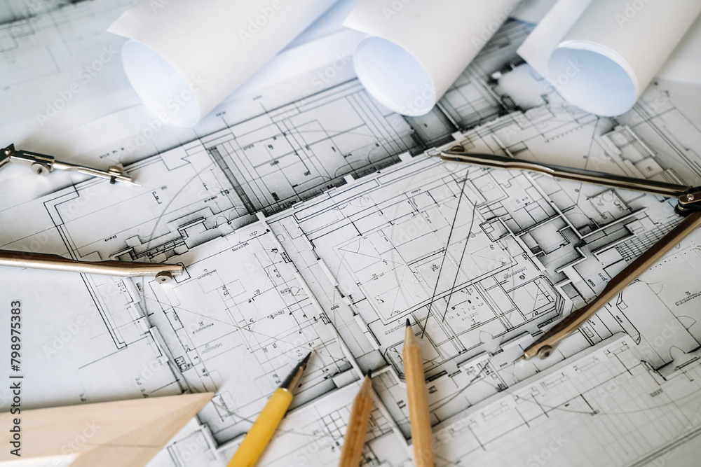 © uladzimirzuyeu - Architectural engineering design plan drawing on the table. Architect's work on table in studio. Construction design and plan © uladzimirzuyeu - Architectural engineering design plan drawing on the table. Architect's work on table in studio. Construction design and plan
