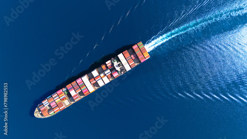 Top view Container ship full capacity approaching the port by a tugboat occupying the port International Container ship loading, unloading at sea port, Freight Transportation, Shipping,