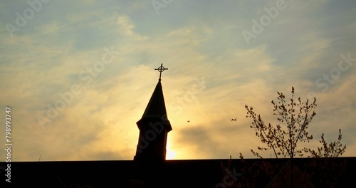 Catholic church's silhouette against vibrant evening sky, echo essence of faith and religion. Sunset envelope Catholic church, silhouette grace sky, metaphor for soaring spirit of faith.