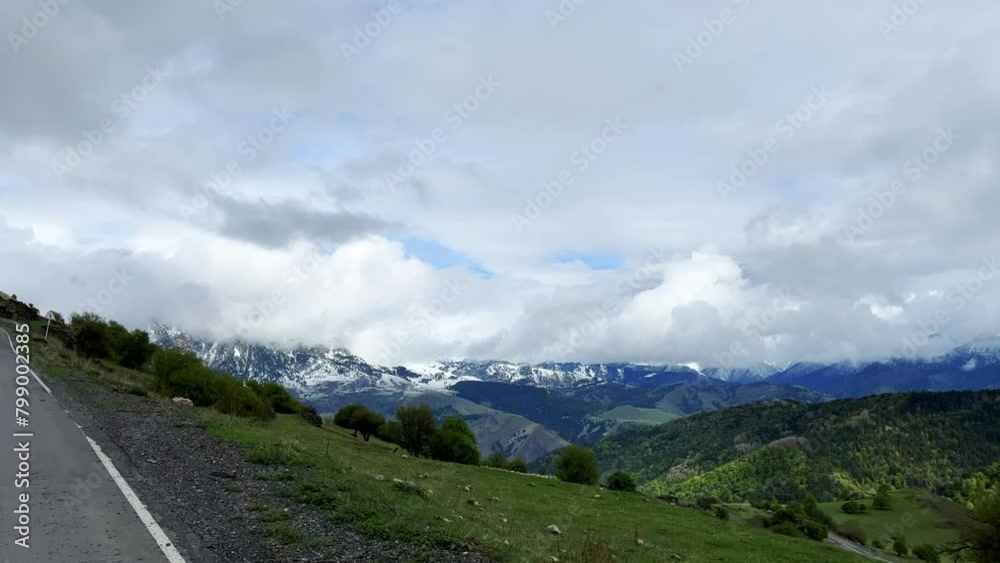 Ceylomsky pass from a car window in Ingushetia. A trip uphill to the Tsei Loam pass on a cloudy spring day. Panorama of the high cliffs of the Dzheyrakh gorge. The Caucasus, the mountains in the fog. Ceylomsky pass from a car window in Ingushetia. A trip uphill to the Tsei Loam pass on a cloudy spring day. Panorama of the high cliffs of the Dzheyrakh gorge. The Caucasus, the mountains in the fog.