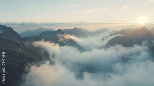 A mountain pass with clouds rolling through peaks at sunrise