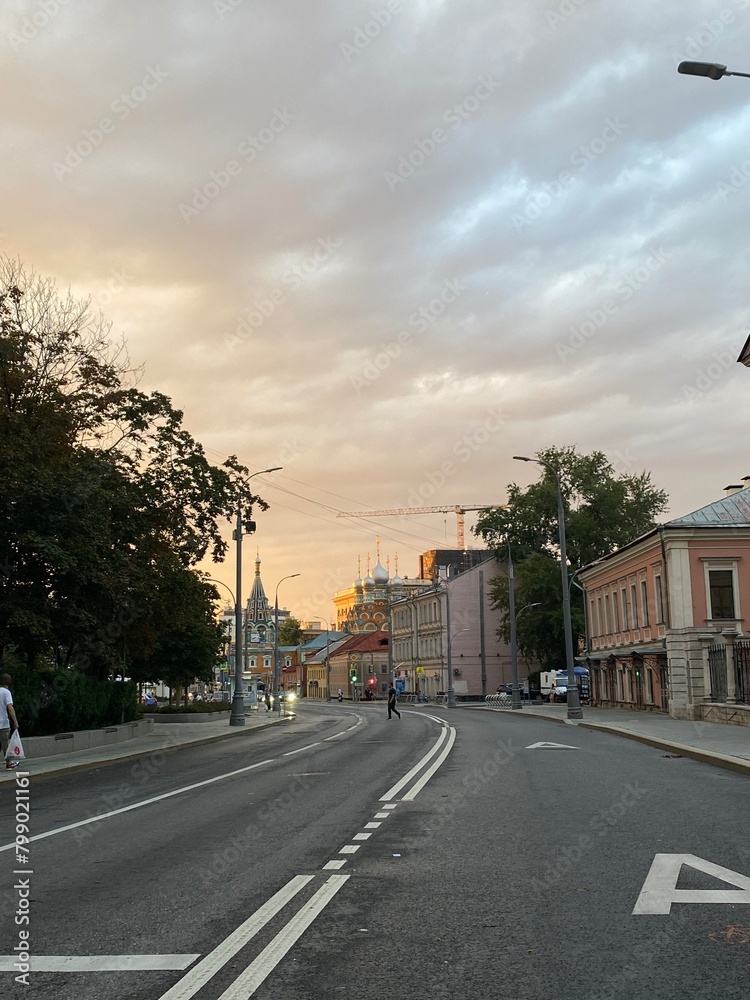 summer evening on the roadway in the city center with a view of old houses and a church