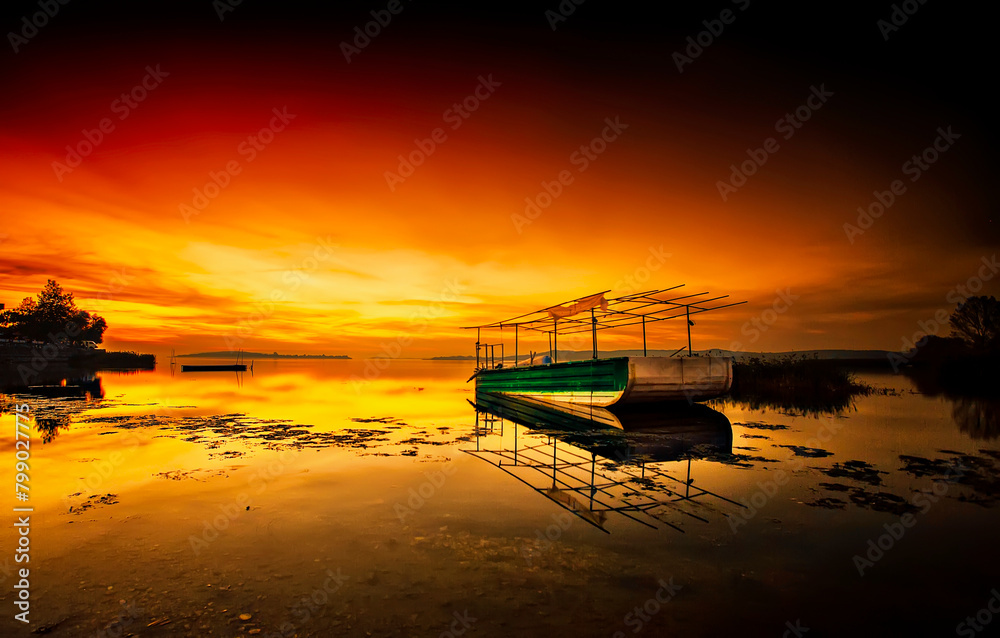 Wide view of fisherman boats in Ulubat Lake, Golyazi, Bursa, Turkey, big tree lakeside, sunset