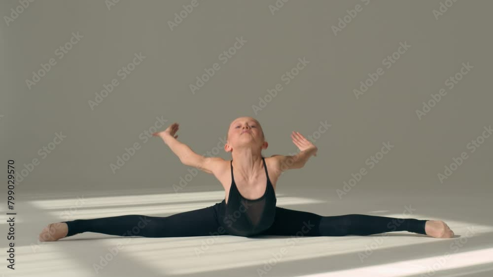 Little girl gymnast stretching aerobic on floor in dance studio ballet school Caucasian female acrobat ballerina dancer kid child sitting in split position bend flexibility rhythmic gymnastics sport