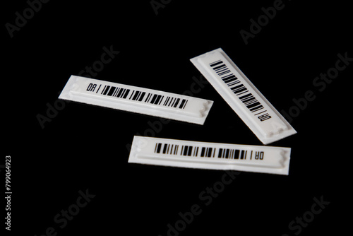 Fotografie Labels with anti-theft barcodes on a black background
