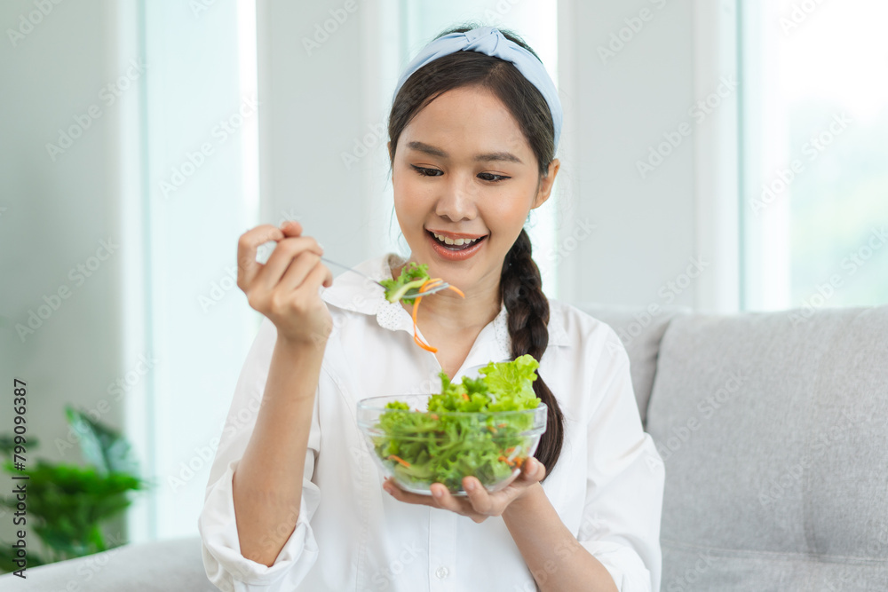 Cheerful vegetarian woman eating a bowl of homemade salad as breakfast. Cheerful vegetarian woman eating a bowl of homemade salad as breakfast.