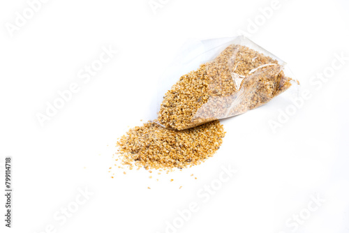 Dry food Daphnia for aquarium fish poured out of a plastic bag on a white background