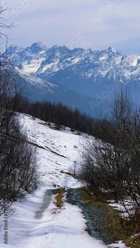 Archonsky Pass. The pass connects the Kurtatinsky gorge with the Alagirsky. Alanya, view of the mountains of the North Caucasus, peaks covered with snow. Sunny day, blue sky with a slight haze. 4К photo