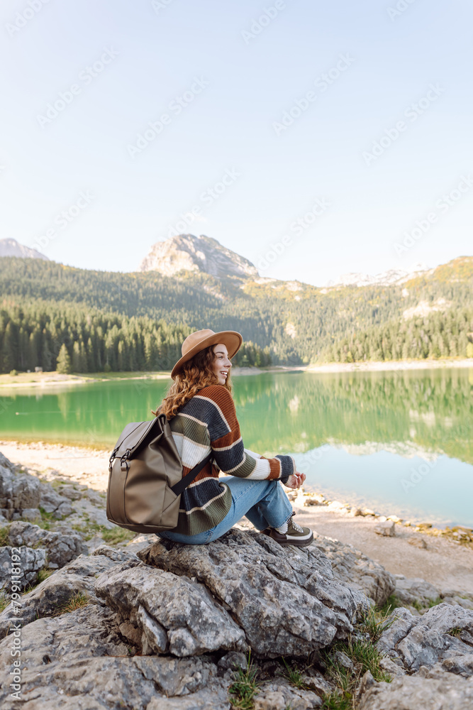 Young woman sitting on the hill and enjoying nature. Active life. Lifestyle, travel, tourism