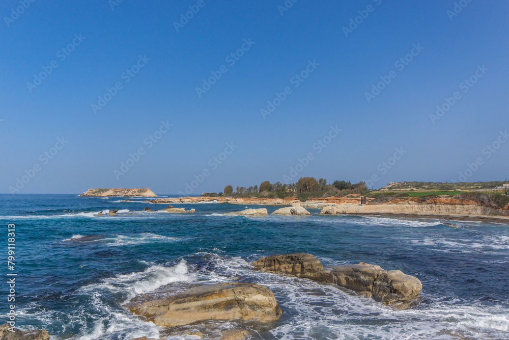 Waves Crashing on Rocky Beach. The white foamy spray contrasts with the dark tones of the rocks, illustrating the harsh beauty of the coastal landscape Waves Crashing on Rocky Beach. The white foamy spray contrasts with the dark tones of the rocks, illustrating the harsh beauty of the coastal landscape