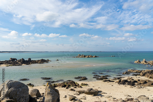 Dans le Finistère nord, plage de sable blanc, rochers et eaux transparentes sous un ciel bleu parsemé de nuages en Bretagne. © Laurent