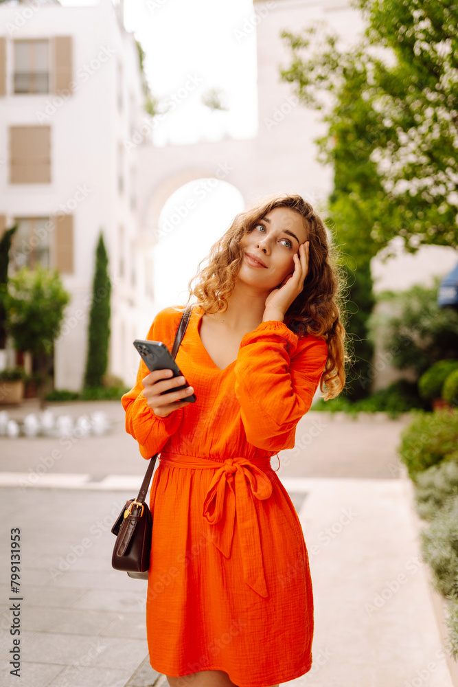 Woman traveler with a mobile phone. Happy Woman texting, browsing, using her smartphone on a warm sunny day. Positive emotions. Apps. Woman traveler with a mobile phone. Happy Woman texting, browsing, using her smartphone on a warm sunny day. Positive emotions. Apps.