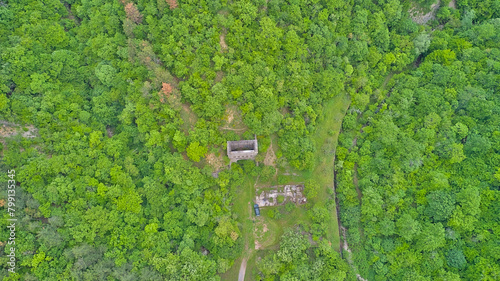 An unfinished abandoned entrance to a tunnel in the forests amidst the mountains. An incomplete railway tunnel in the mountains of Bulgaria. Aerial photo taken from a drone.