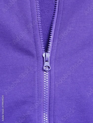 Closeup of half closed plastic zipper at purple cotton casual sweatshirt