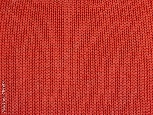 Closeup of orange knitted fabric with large stitches. Textured unicolor background.