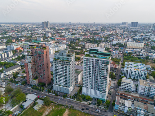 Several tall buildings with recreation areas and swimming pools on the roof, next to a building with solar panels and the redesign of the car street area, aerial top view