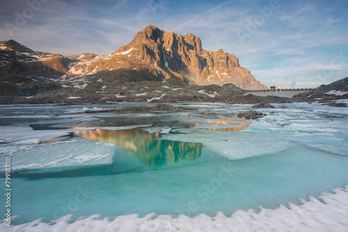 Frozen Vacca lake at sunset during spring season, Adamello park, Lombardy, Italy.	 photo
