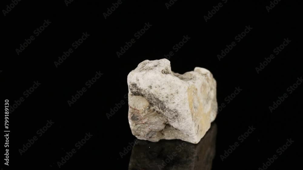 Polished mineral stone phlogopite rotates in a circle on a black background