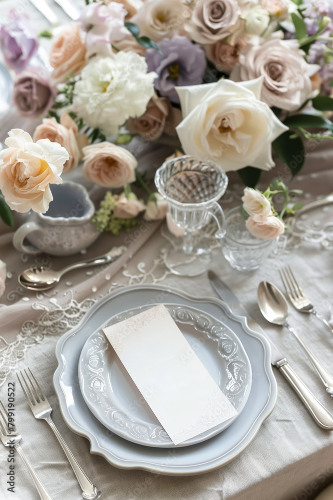 A beautifully decorated table with linen tablecloth, crystal glasses, vintage flatware, silverware and a blank menu card A beautifully decorated table with linen tablecloth, crystal glasses, vintage flatware, silverware and a blank menu card