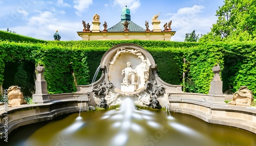 fountain in the park of palace,. The garden has several sculptures and fountains, and is surrounded by trees. The palace and garden. photo